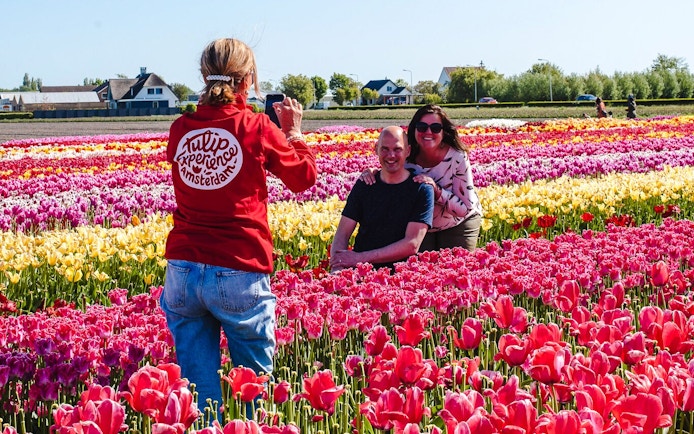 Guests posing in colorful tulip fields during the Tulip Experience tour at Keukenhof.