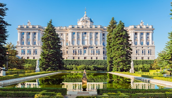 Royal Palace of Madrid exterior with ornate architecture and tourists in the foreground.