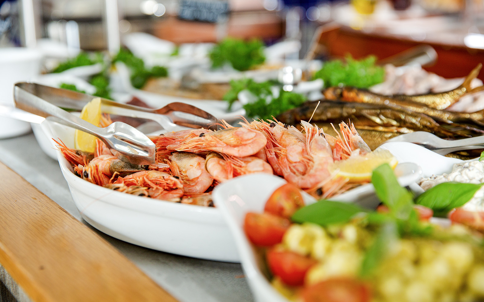 Shrimp buffet with lemon wedges and fresh herbs on a serving platter.