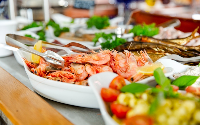 Shrimp buffet with lemon wedges and fresh herbs on a serving platter.