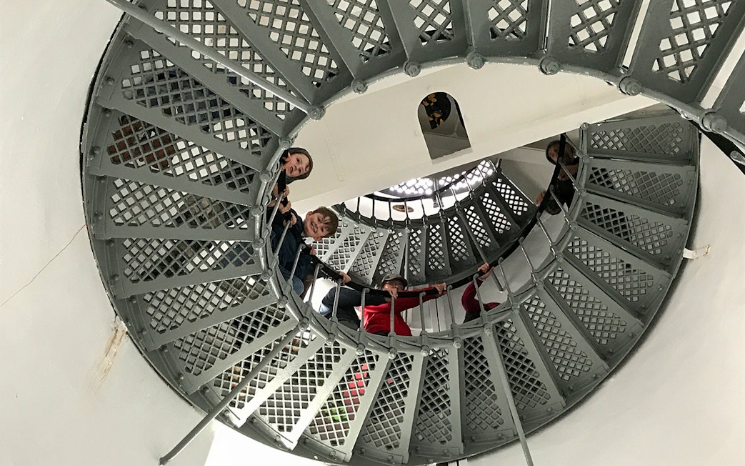 Visitors ascending spiral staircase inside Bruny Island lighthouse, Hobart tour.