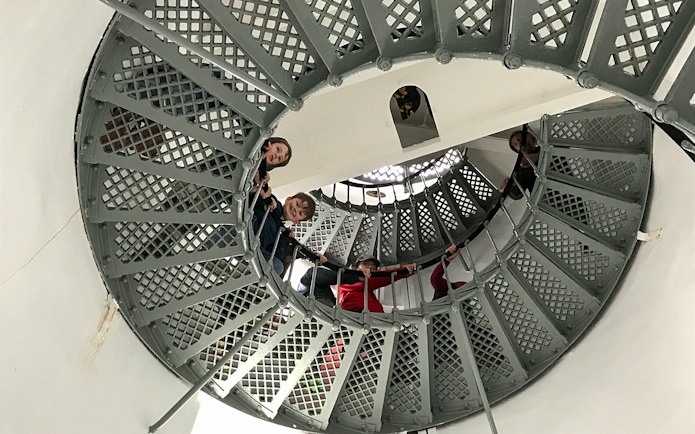 Visitors ascending spiral staircase inside Bruny Island lighthouse, Hobart tour.