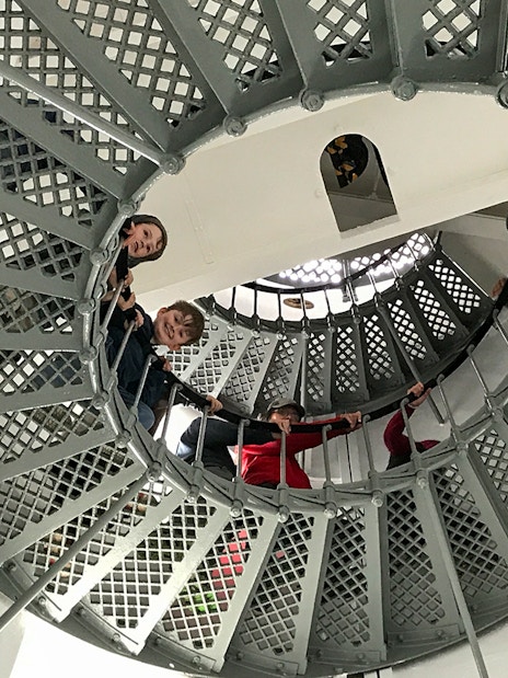 Visitors ascending spiral staircase inside Bruny Island lighthouse, Hobart tour.