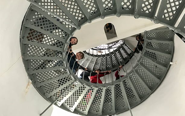 Visitors ascending spiral staircase inside Bruny Island lighthouse, Hobart tour.