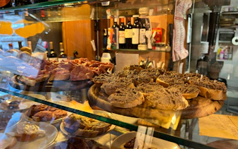 Traditional Tuscan crostini with liver pâté and cured meats in a Florence deli.