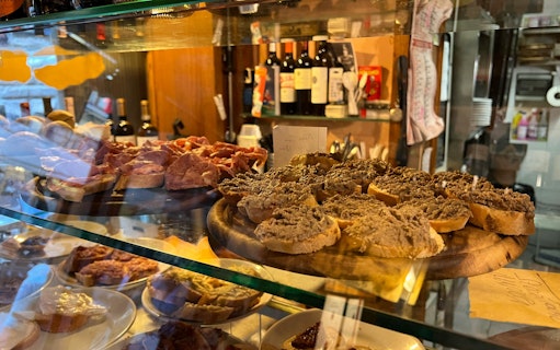 Traditional Tuscan crostini with liver pâté and cured meats in a Florence deli.