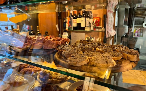 Traditional Tuscan crostini with liver pâté and cured meats in a Florence deli.