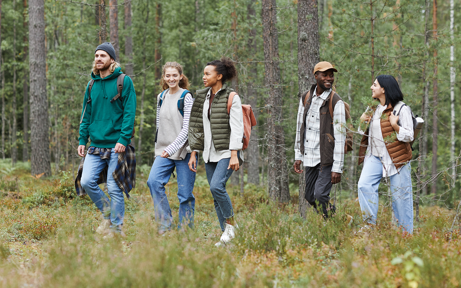 Hikers trekking through lush forest towards Piscina Irgas waterfall in Villacidro, Cagliari.