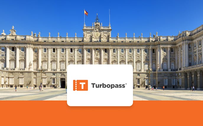Royal Palace of Madrid facade with visitors in the courtyard.