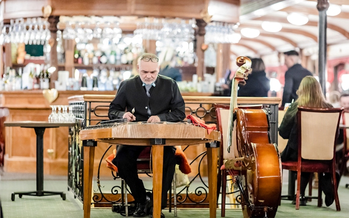 Musician playing traditional instrument on Budapest Danube River evening cruise with live Hungarian folk music.