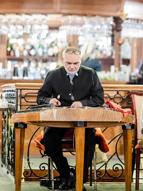 Musician playing traditional instrument on Budapest Danube River evening cruise with live Hungarian folk music.