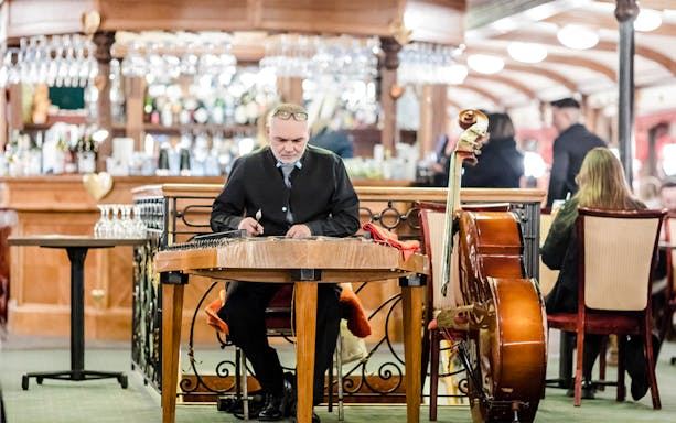 Musician playing traditional instrument on Budapest Danube River evening cruise with live Hungarian folk music.