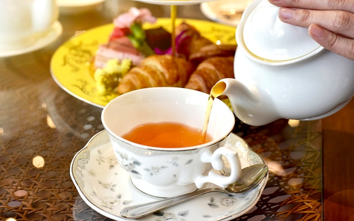 Tea being poured into a cup at Ore Ducasse Restaurant, Palace of Versailles.