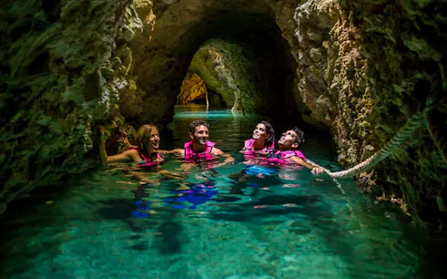 Visitors swimming in an underground river at Xcaret Park.