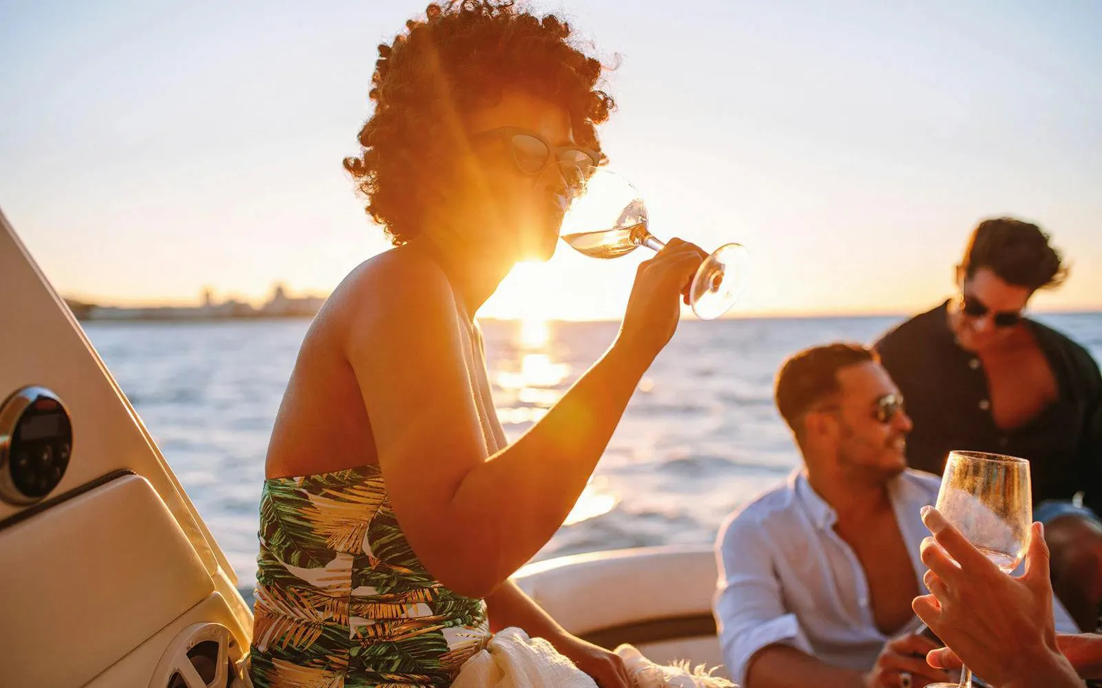 People enjoying drinks on a boat during an Algarve sunset experience.