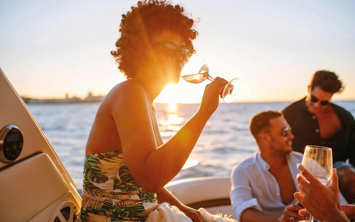 People enjoying drinks on a boat during an Algarve sunset experience.
