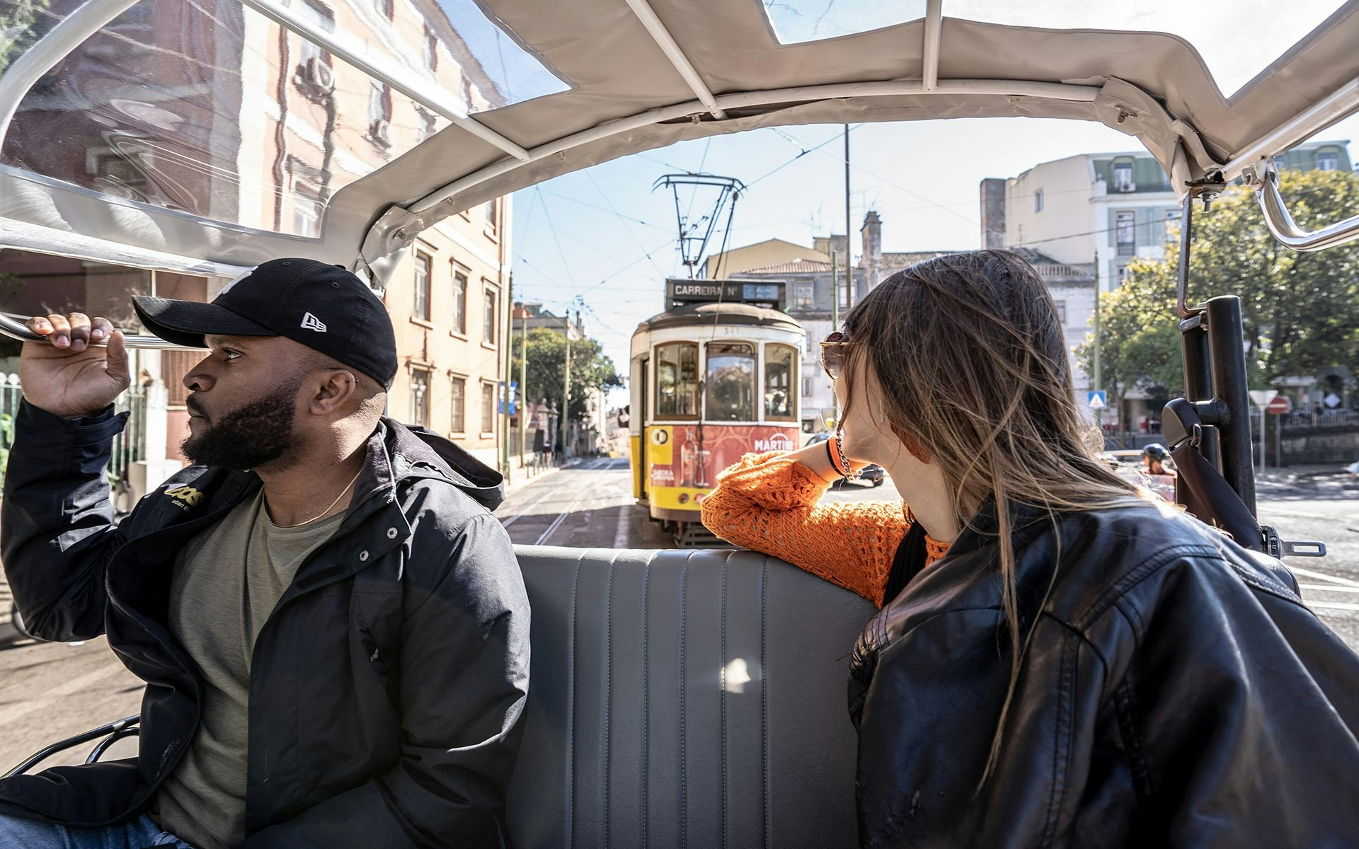 Tuk tuk passengers following Lisbon tram route.