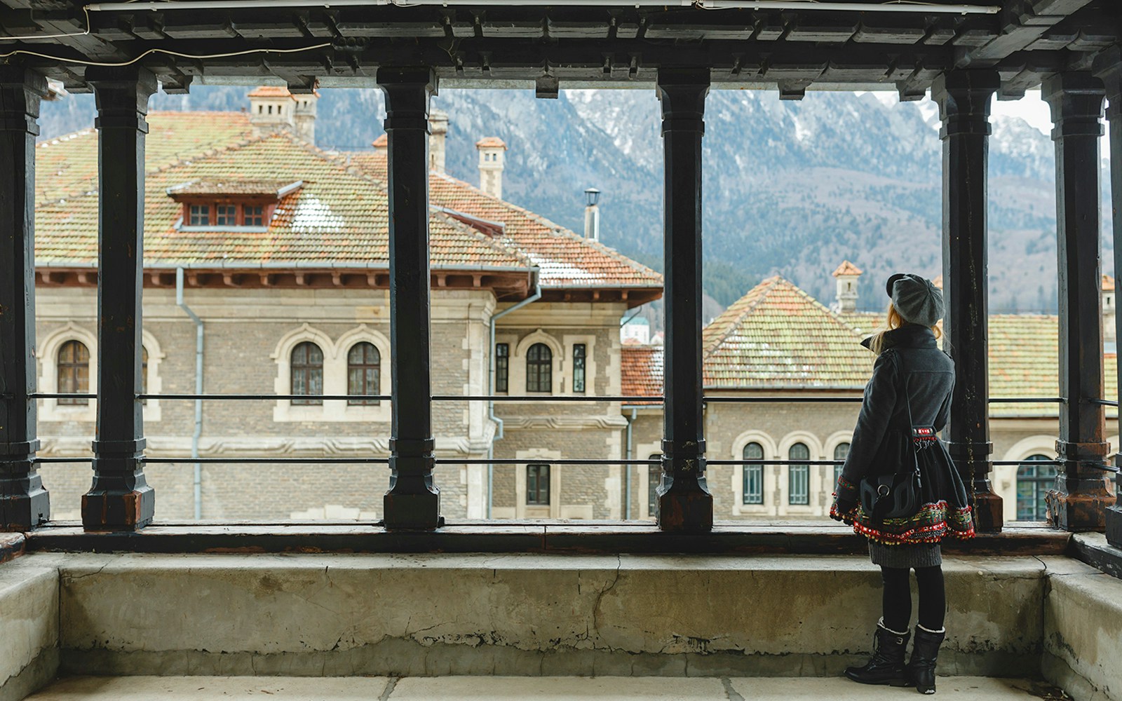Guest viewing Peles Castle courtyard through window, Sinaia, Romania.