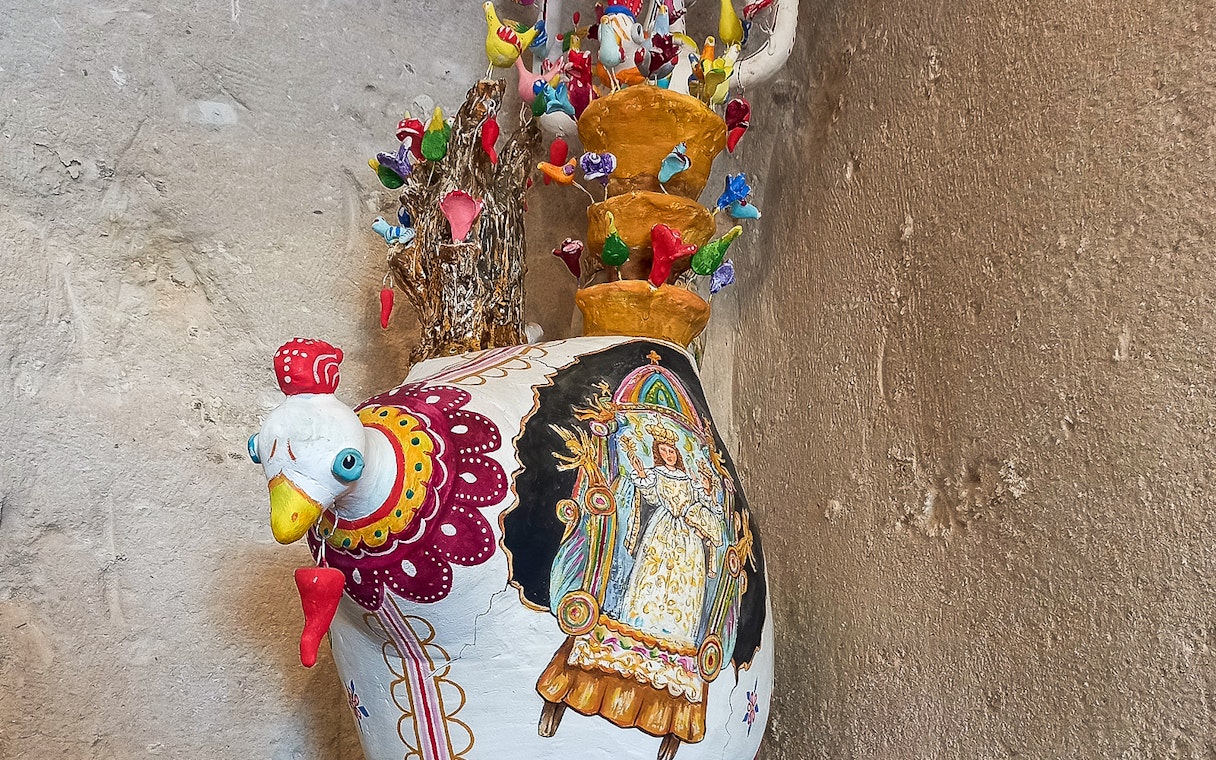 Colorful ceramic rooster vase with intricate designs in Casa Grotta, Matera.