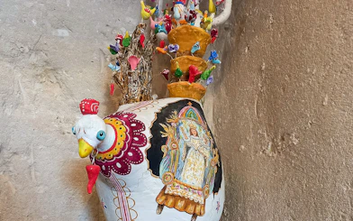 Colorful ceramic rooster vase with intricate designs in Casa Grotta, Matera.