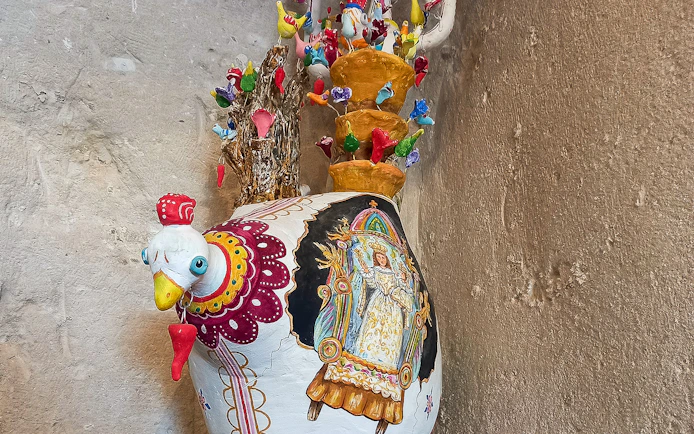 Colorful ceramic rooster vase with intricate designs in Casa Grotta, Matera.