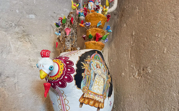 Colorful ceramic rooster vase with intricate designs in Casa Grotta, Matera.