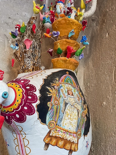 Colorful ceramic rooster vase with intricate designs in Casa Grotta, Matera.