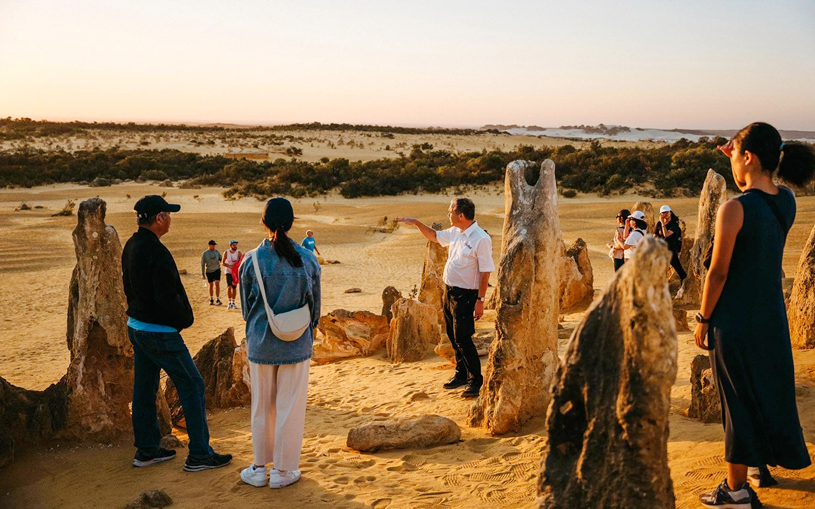Group exploring Pinnacles Desert at sunset during stargazing and wildlife tour.