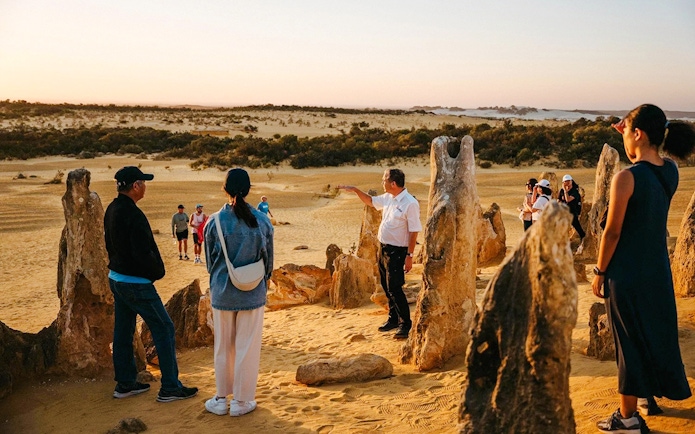Group exploring Pinnacles Desert at sunset during stargazing and wildlife tour.
