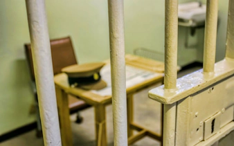 Prison cell interior at Robben Island with table and chair.