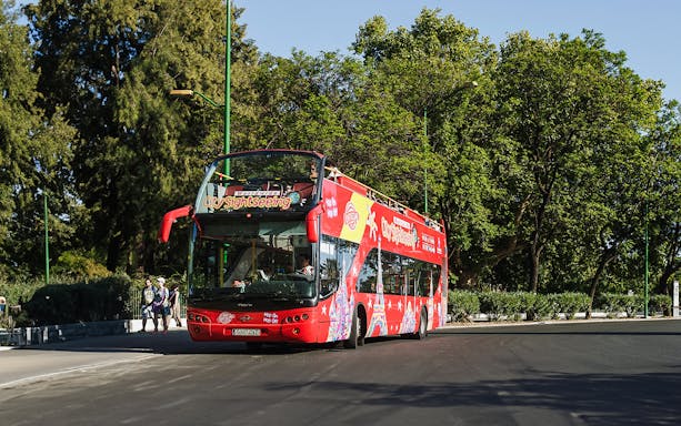 Double-decker sightseeing bus on a Hanoi city tour with tourists onboard.