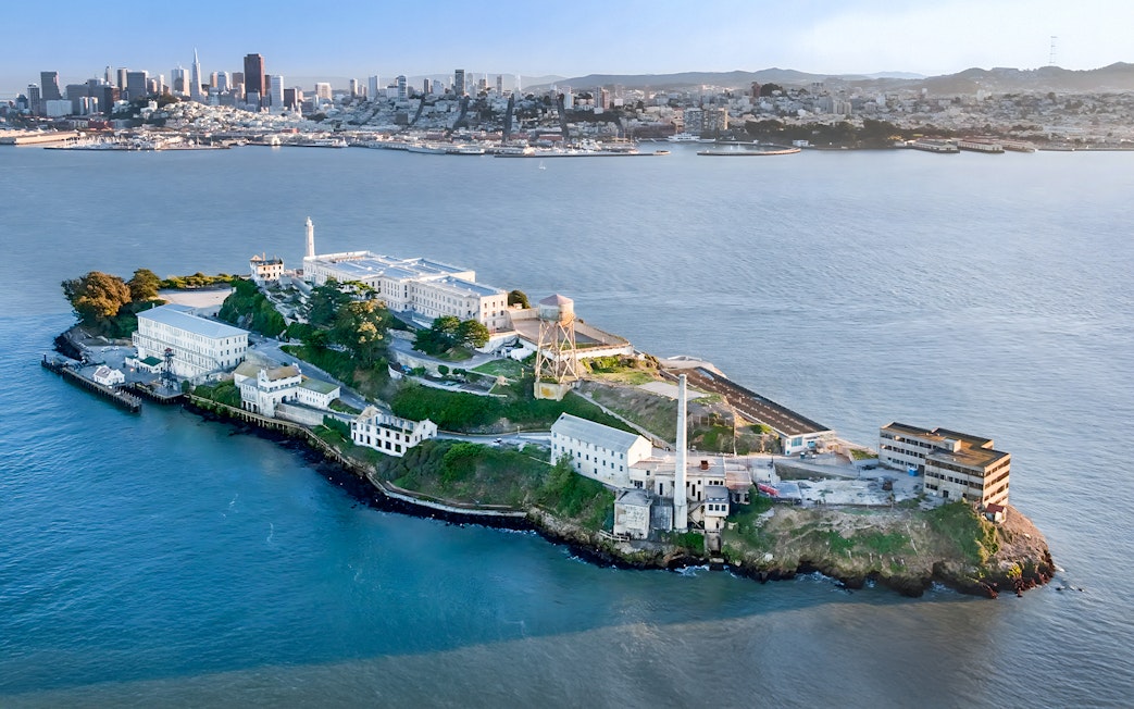 Aerial view of Alcatraz Island with San Francisco skyline in the background.