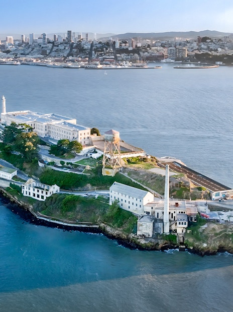 Aerial view of Alcatraz Island with San Francisco skyline in the background.