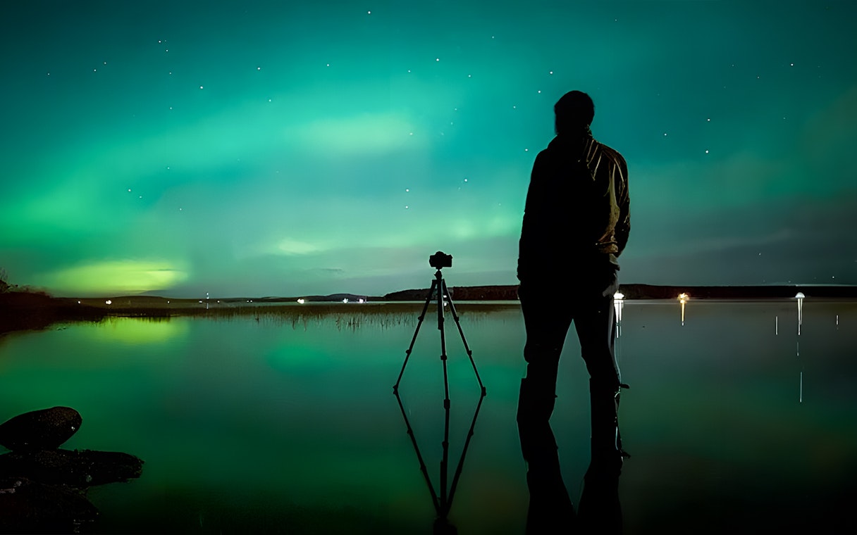 Photographer capturing Northern Lights in Rovaniemi on a guided tour.