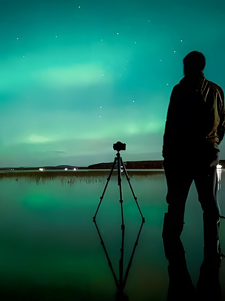 Photographer capturing Northern Lights in Rovaniemi on a guided tour.