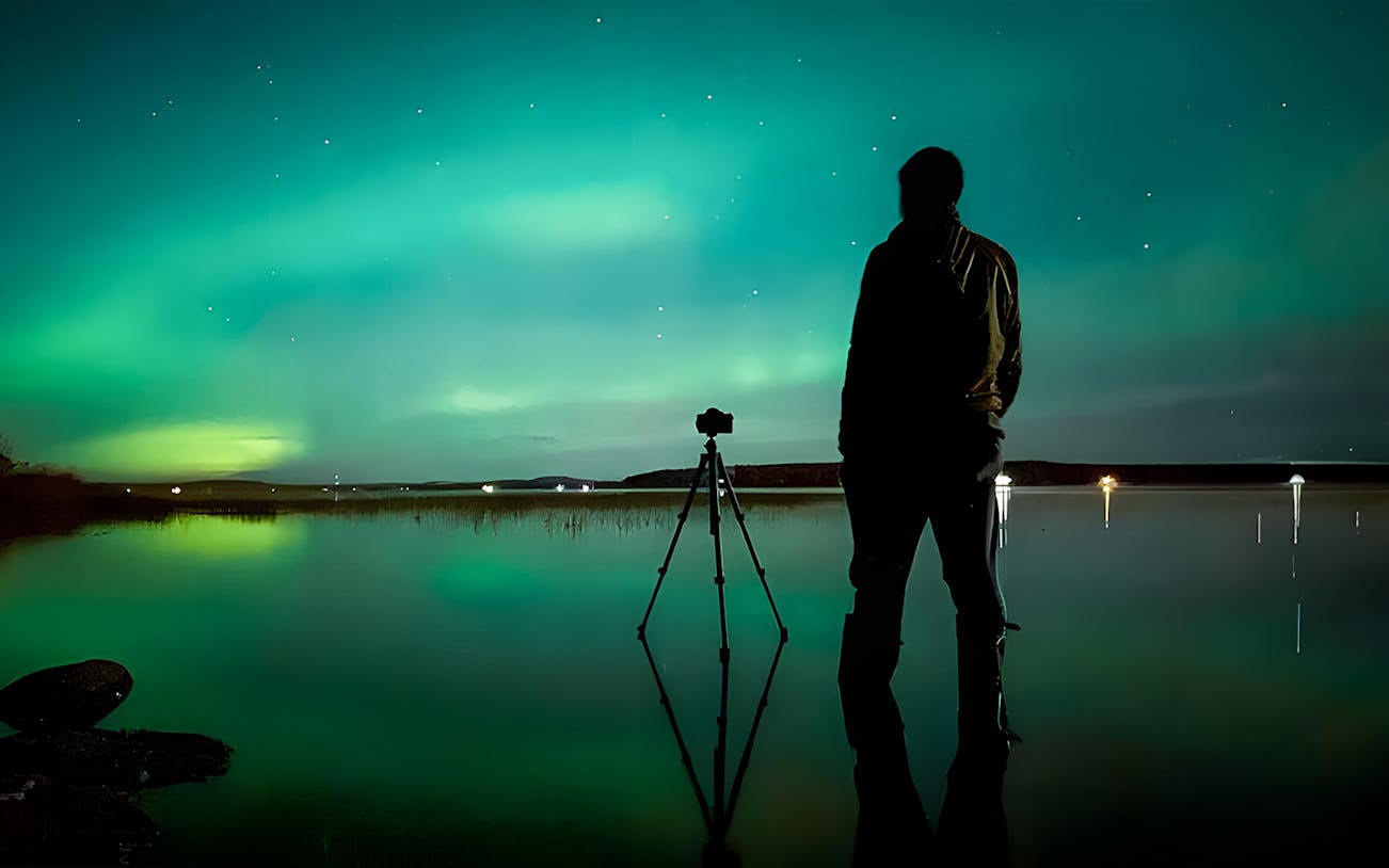 Photographer capturing Northern Lights in Rovaniemi on a guided tour.
