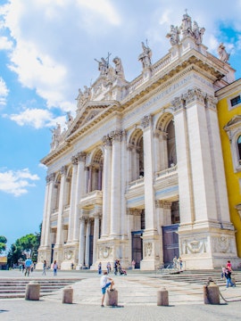 St. John Lateran Basilica facade with visitors in Rome, Italy.