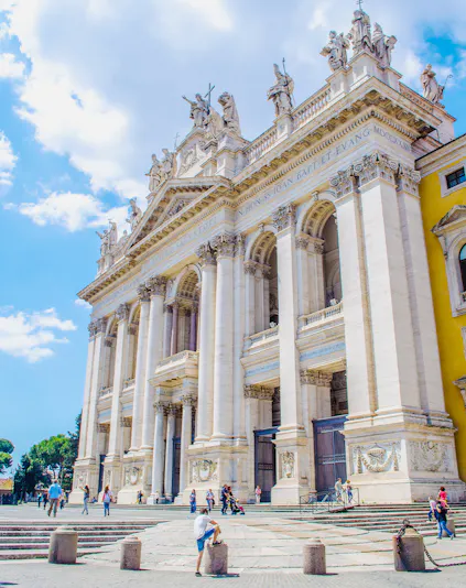 St. John Lateran Basilica facade with visitors in Rome, Italy.