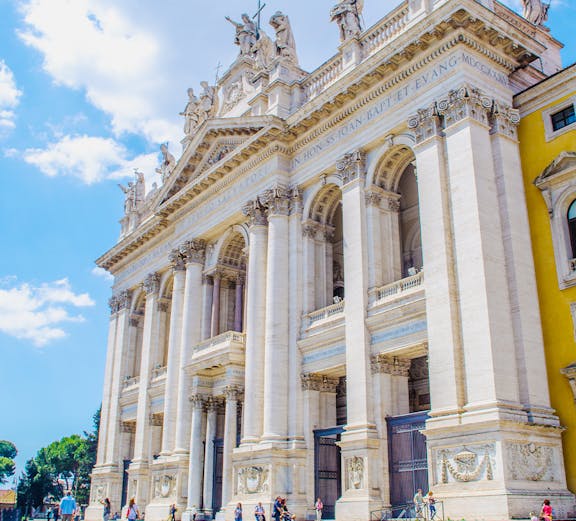St. John Lateran Basilica facade with visitors in Rome, Italy.