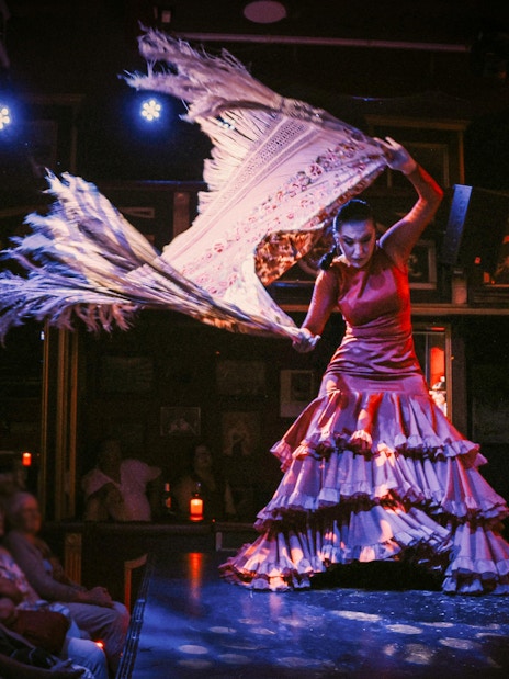 Flamenco dancer performing at Teatro Flamenco Málaga Club with audience watching.