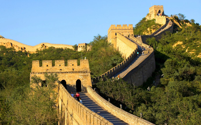 Great Wall of China at Badaling with tourists walking along the stone path.