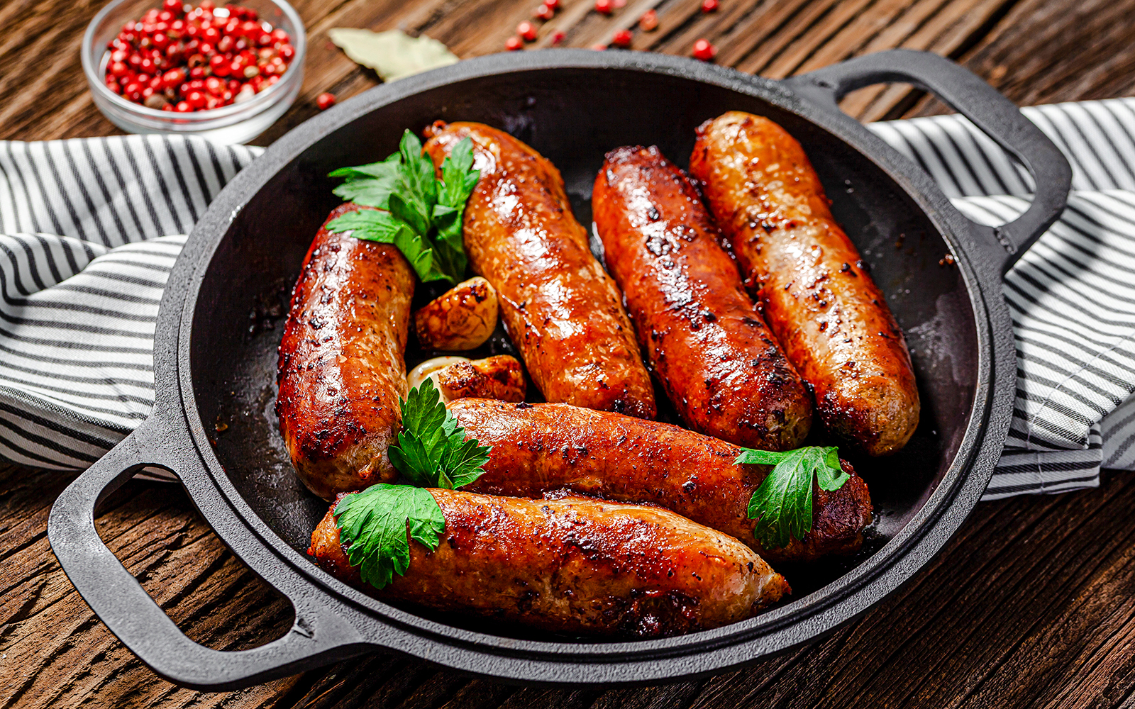 Pork sausages garnished with herbs in a skillet at Castas e Pratos, Douro Valley.