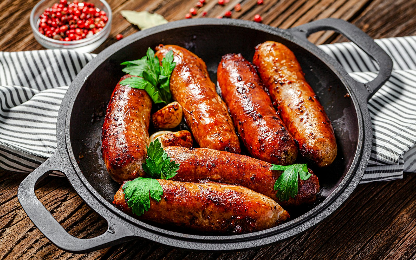 Pork sausages garnished with herbs in a skillet at Castas e Pratos, Douro Valley.