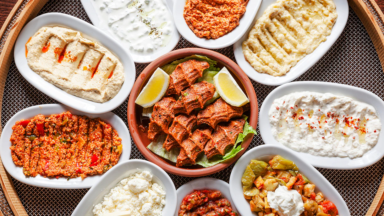 Turkish meze platter with various dishes including hummus and spicy bulgur salad.