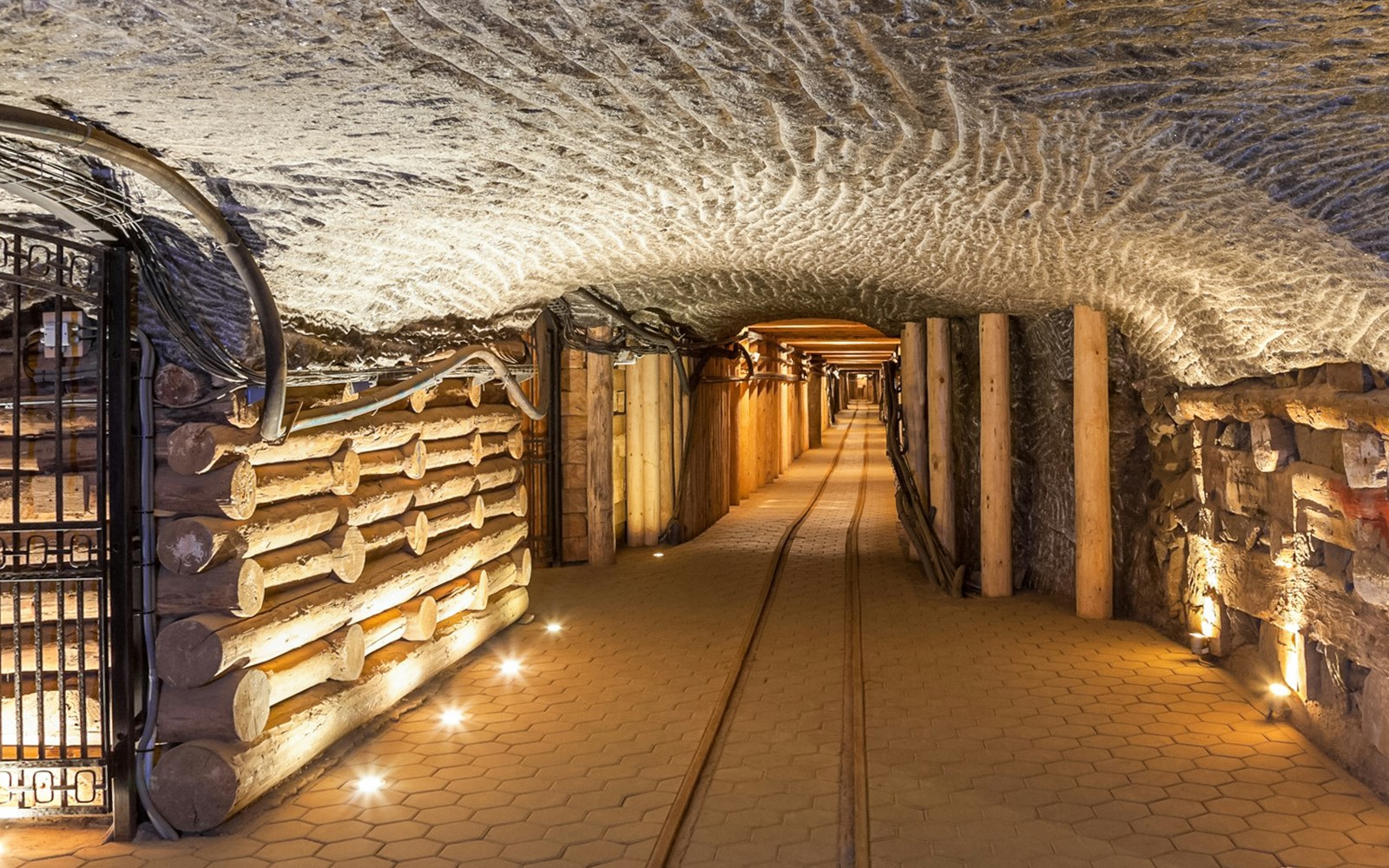 Wieliczka Salt Mine underground tunnel with wooden supports and illuminated path.