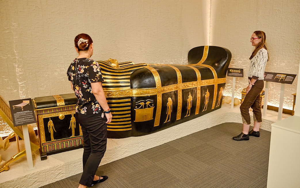 Visitors viewing Egyptian sarcophagus at Tomb of the Pharaoh exhibit, Cairns.