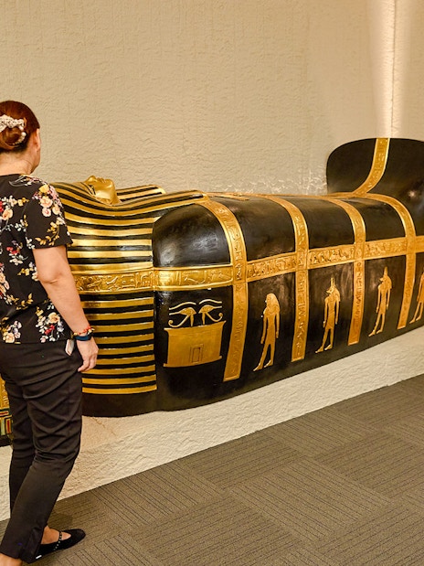 Visitors viewing Egyptian sarcophagus at Tomb of the Pharaoh exhibit, Cairns.