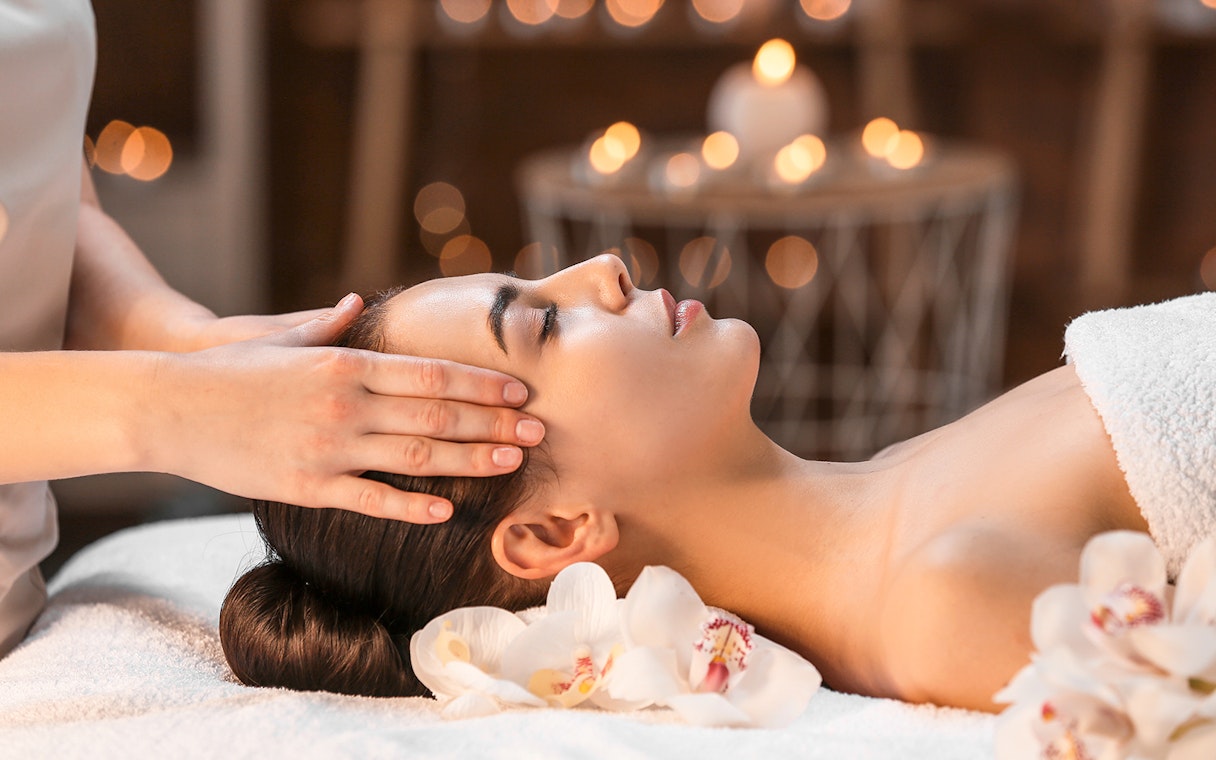 Woman receiving a head massage at Therme Erding Tropical Spa.
