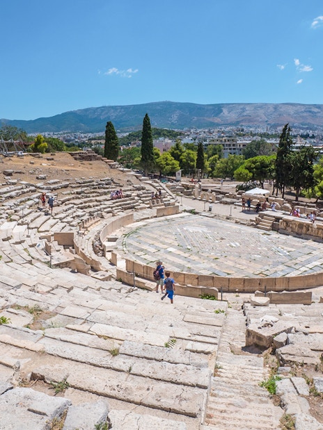 Theatre of Dionysus ruins with visitors, Acropolis, Athens, Greece.