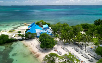Resort with blue buildings and beach chairs on a sandy shore in Rosario Islands, near Cartagena, Colombia.